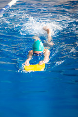 Wall Mural - Cute little girl swimmer training in a swimming pool