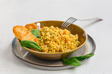 Poster - Ptitim with chicken schnitzel. Ptitim - or Israeli couscous - toasted paste. Made with fried onion, carrot, tomato and spinach.