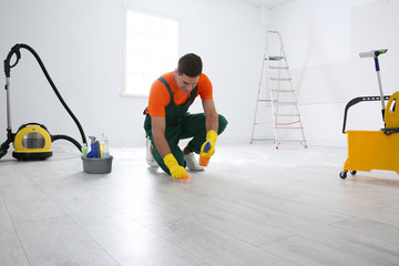 Poster - Professional janitor cleaning floor with brush and detergent after renovation