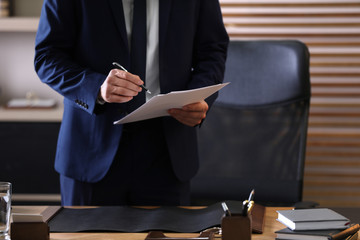 Wall Mural - Male lawyer working at table in office, closeup