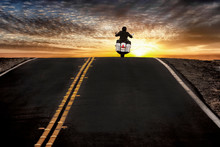 Motorcycle Rider On Street Riding Toward Sunset Sky