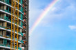 High-rise building under construction, with rainbow