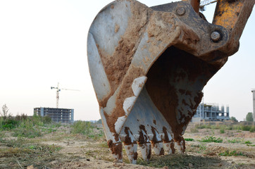 Poster - Large metal iron ladle. Excavator bucket for digging a pit for pouring concrete for the construction of a multi-story residential building at a construction site