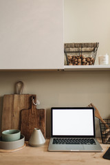 Wall Mural - Kitchen workspace with blank copy space mock up laptop screen. Modern stylish kitchen interior design with wooden kitchenware. Front view blog, social media, website hero header template.
