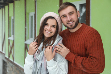 Sticker - Lovely couple wearing warm sweaters outdoors on snowy day. Winter season