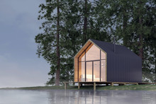 Secluded Tiny House On The Sandy Shore Of A Lake With Fog In A Coniferous Forest In Cold Cloudy Lighting With Warm Light From The Windows. Stock 3D Illustration
