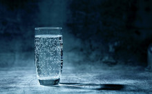 Glass Of Sparkling Water On The Grey Background