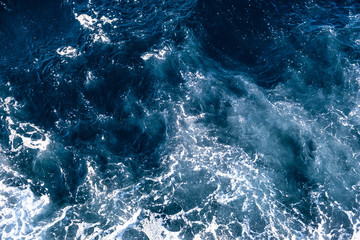 Top down aerial view of sea water surface. White foam waves texture as natural background.