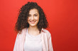 © denis_vermenko - Happy cheerful young woman with curly hair rejoicing at positive news or birthday gift, Student girl relaxing after college isolated over red background.