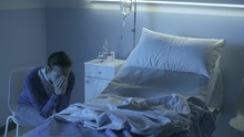 Sad Woman Crying Next To An Empty Hospital Bed