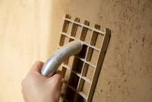 Closeup Of A Plasterer Finishing A Wall Made Of Clay Plaster With A Board