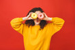 © denis_vermenko - Close up portrait of a satisfied pretty young girl eating donuts isolated over red background.