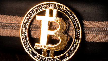 Bitcoin coin, BTC. Bitcoin gold coin with program code next to the zipper, close-up. Symbol of cryptocurrency and electronic money, blockchain. Cryptocurrency exchange and investment concept. 