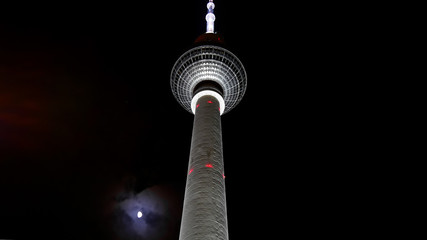 Wall Mural - Berlin television Tower. Famous TV tower at Alexanderplatz at night, against a black sky with a large, white, luminous moon. 