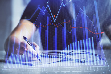 Multi exposure of woman's hands making notes with forex graph hologram. Concept of technical analysis.