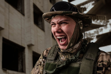 A close-up shot of a military man in a uniform in a hat with goggles giving orders in front of a building. Soldier in the panic.