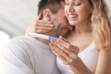 Sticker - Happy young couple with pregnancy test in bathroom, closeup