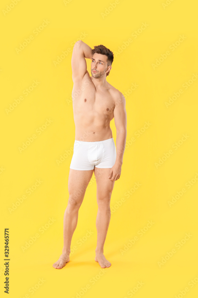 Handsome man in underwear on color background
