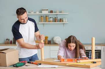 Wall Mural - Young couple assembling furniture at home