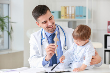 Pediatrician examining little baby in clinic