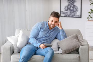 Sticker - Handsome man with tablet computer at home