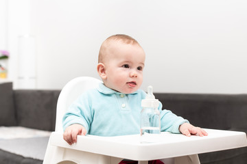 Wall Mural - Portrait Of Baby Child With Bottle In Chair