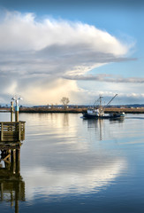 Wall Mural - Fraser River Seiner and Cloud. A seine boat travels up the Fraser River. Storm clouds loom in the background.