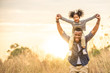 © CandyRetriever  - Happy Mixed race African family little child girl sitting on her father neck while hiking on the mountain at sunset with smiling face. Parent and kid enjoy and having fun in summer vacation