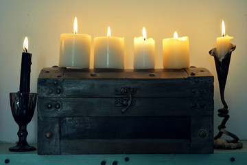 Ritual wooden box with burning candles.