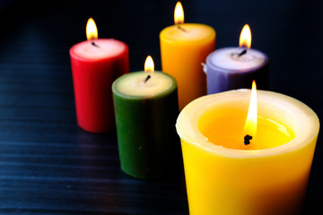 Close up of colorful burning candle at night 