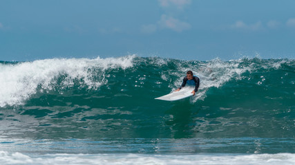 A beginner surfer on a big wave can not resist the guy