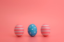 Row Of Three Decorated Easter Eggs On A Pink Background. Striped Pink And A Blue Eggs In A Circle Isolated On Pink. White Lines. Happy Easter Concept. Copy Space.