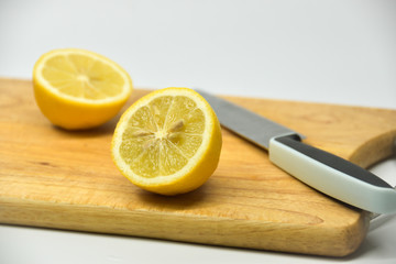 Two pieces of lemon on a wood cutting board.