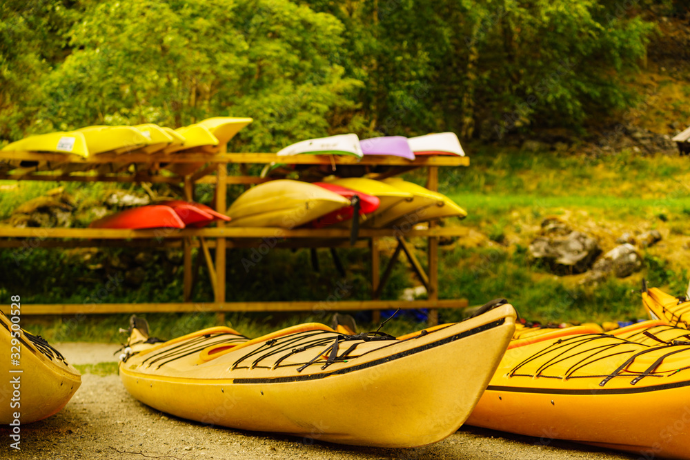 Kayaks on water shore. Rental area - obrazy, fototapety, plakaty 