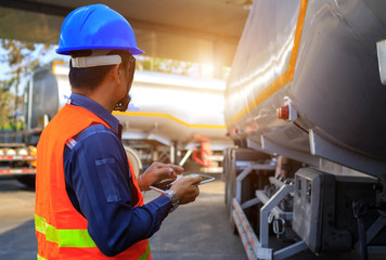 Wall Mural - Truck drivers hand holding tablet checking the product list,Driver writing electronic log books,spot focus.