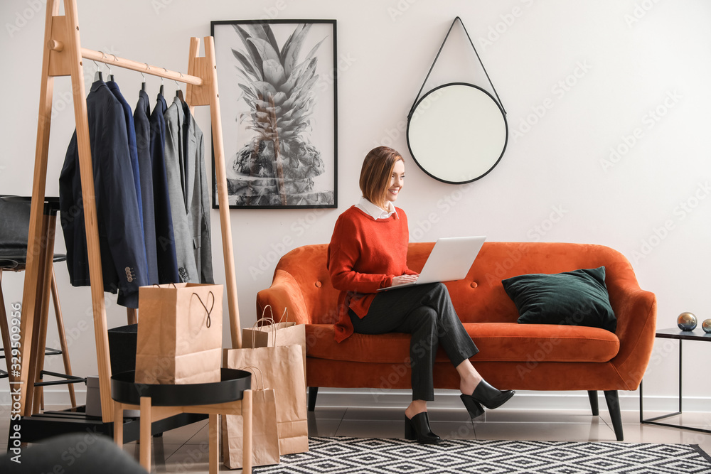 Female stylist with laptop in her studio