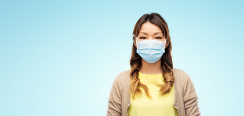 health, safety and pandemic concept - asian young woman wearing protective medical mask for protection from virus disease over blue background