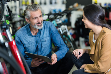 salesman showing bicycle parts to woman