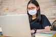 © anuchit2012 - social distancing student concept, Junior high school girl Do homework at home with laptop. the school is closed during an outbreak of the Coronavirus Covid-19 and Dust PM2.5 in Bangkok Thailand