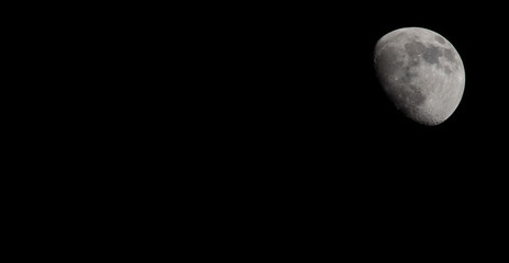 Wall Mural - Closeup of a Three Quarter Moon in a Black Sky