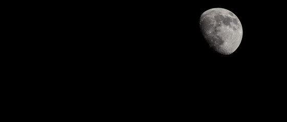 Wall Mural - Closeup of a Three Quarter Moon in a Black Sky