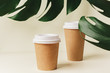 © fotofabrika - Disposable paper coffee cup and green leaf. Ecology concept