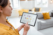 © rh2010 - Woman controlling smart home devices using a digital tablet with launched application. Smart home concept