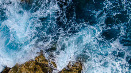 Wild Ocean water from above - Waves hitting the rocks - aerial photography