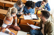 © BalanceFormCreative - Group of university students taking a test in a classroom.Educational concept.