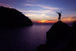 © THANAGON - Silhouette of photographer using camera on the top of a rock by the sea , Twilight  sky sunset