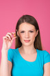 © oreans - beautiful young woman holding pill or capsule close up isolated on pink background