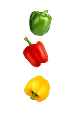 Falling red, yellow and green Bulgarian sweet peppers isolated on white background with clipping path. Flying vegetables