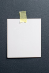 Wall Mural - Blank polaroid photo frame with soft shadows and yellow scotch tape on black craft paper background as template for graphic designers presentations, portfolios etc.