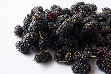 Wall Mural - Mulberries with copy space for text. Black mulberry on white background. Ripe and tasty mulberry Top view.